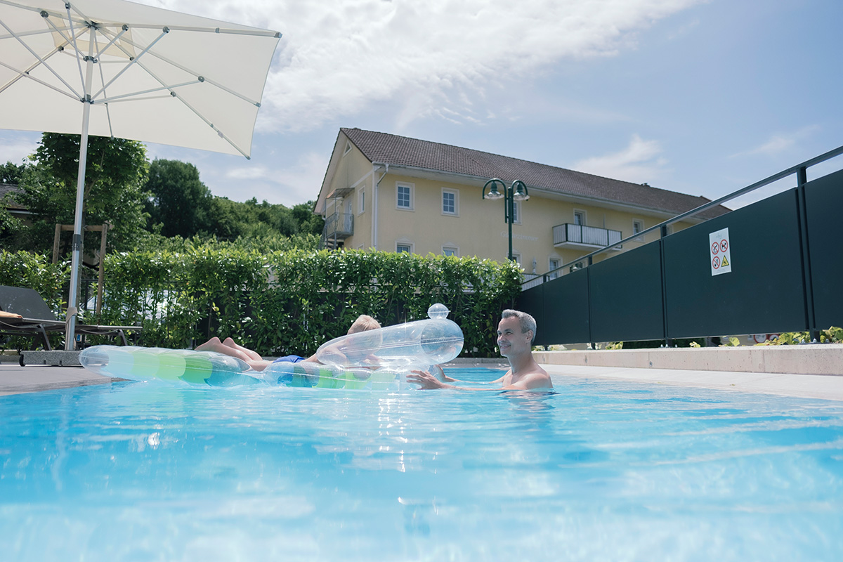 Mann mit Kind im Pool des Landhaus Bad Gleichenberg